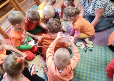 Dzieci siedzą na dywanie