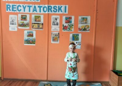 Konkurs recytatorski- stoi dziewczynka, która zajęła I miejsce- młodsza kategoria wiekowa.