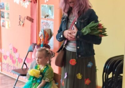 Powitanie wiosny- nauczyciel przebrany za Panią Wiosnę, trzyma w ręku bukiet tulipanów.